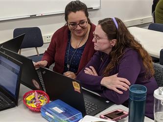 teachers working together in front of a laptop