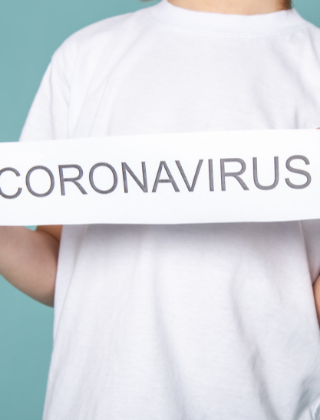 boy with white T shirt holding a corona virus banner boy with white T shirt holding a corona virus banner